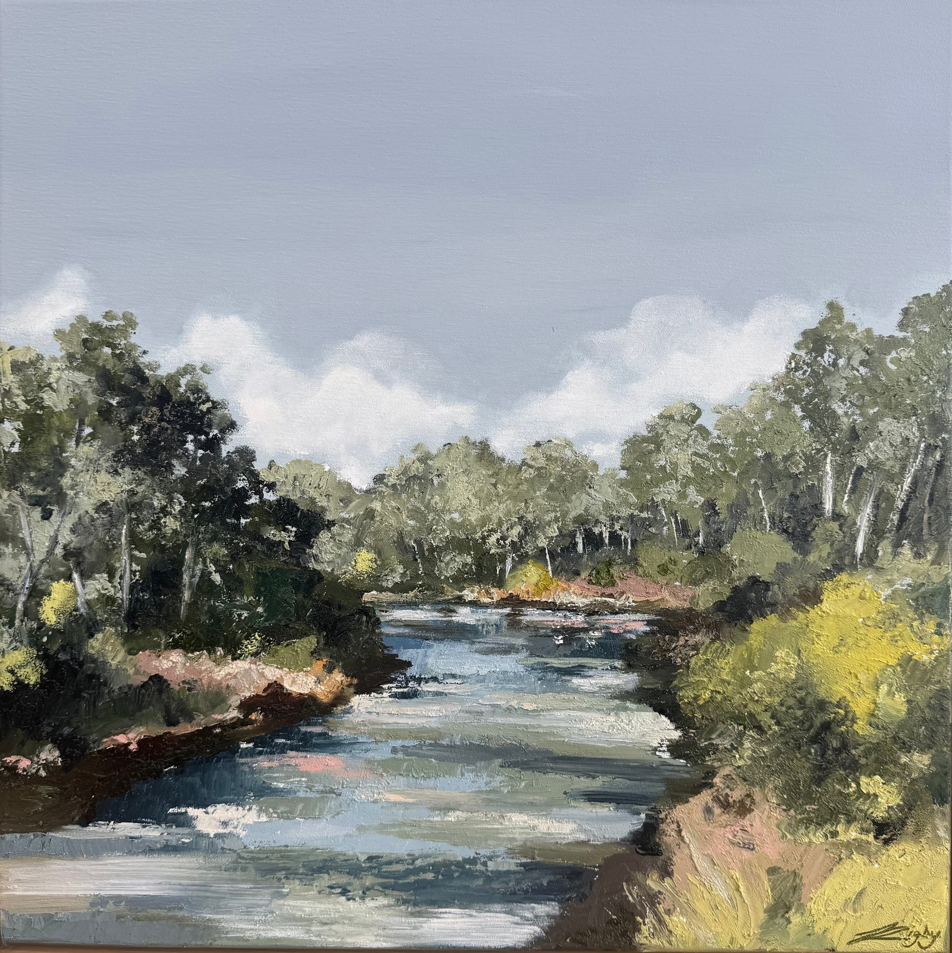 Framed painting of a river landscape with trees and blue sky.