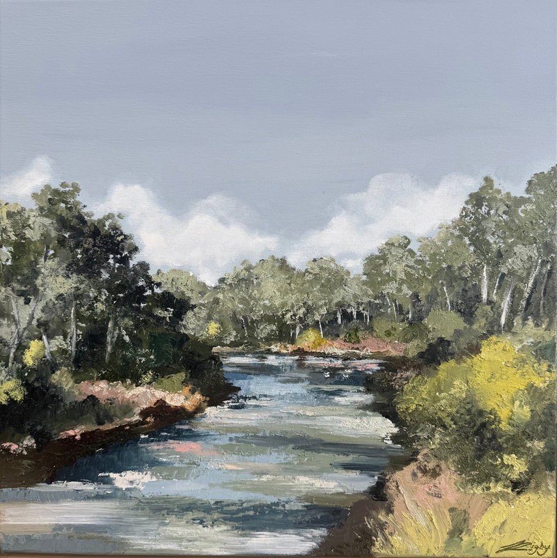 Framed painting of a river landscape with trees and blue sky.