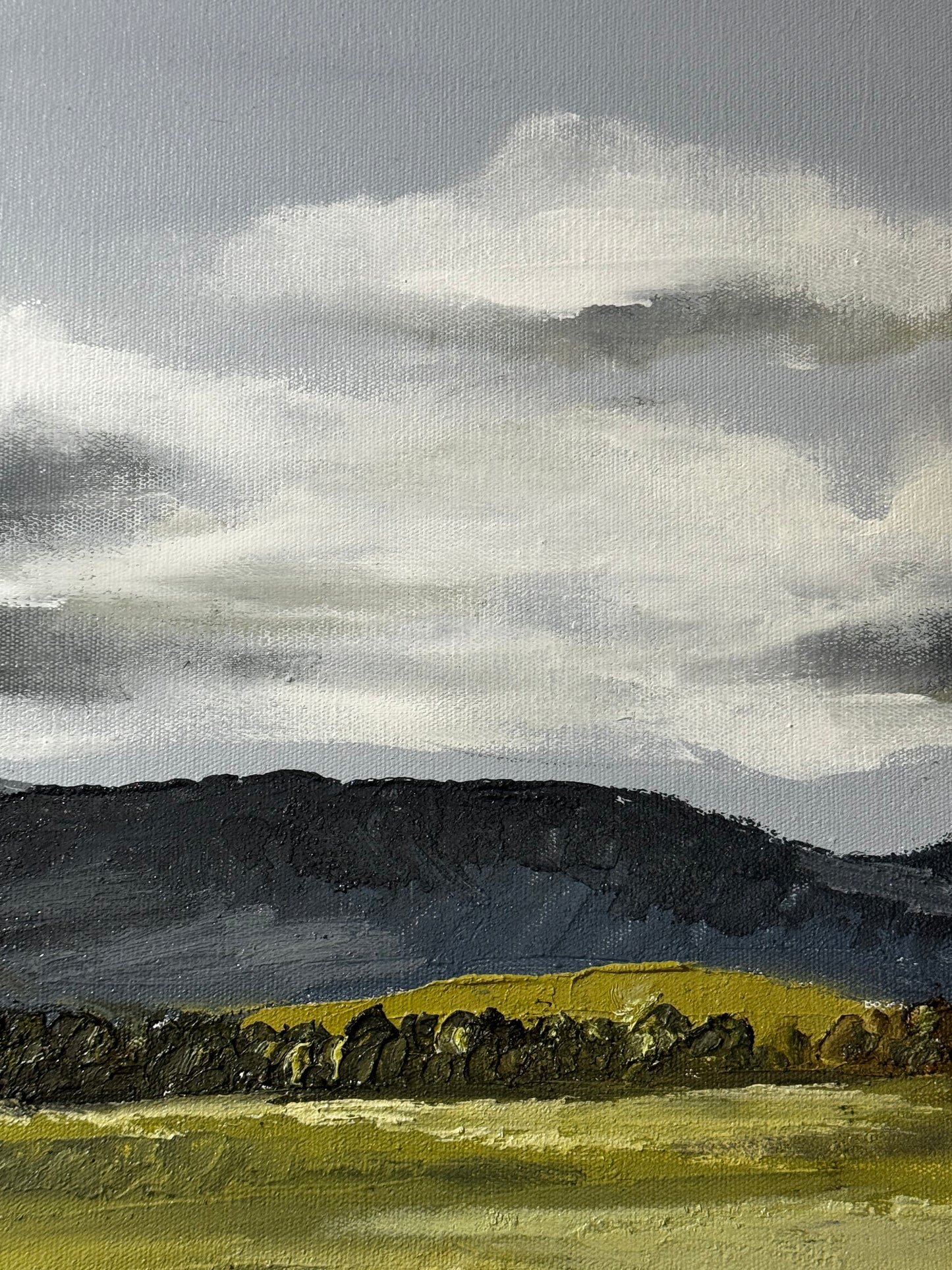 Painting of a landscape with green fields, dark hills, and a cloudy sky.