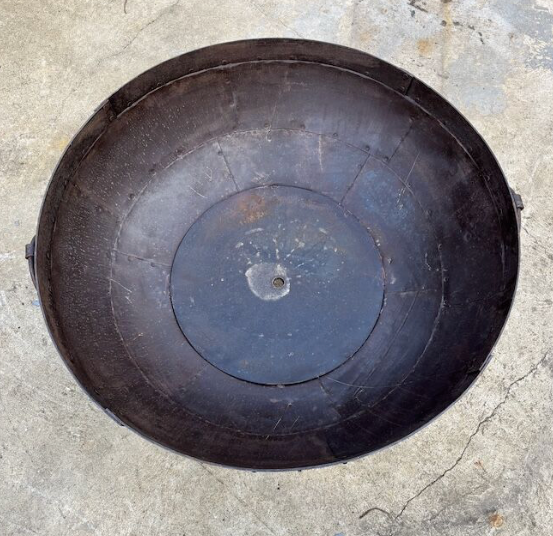Black round fire pit on a concrete surface