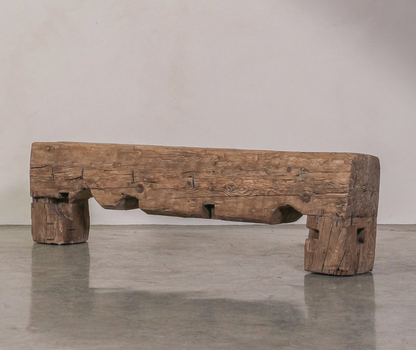 Rustic wooden bench on a gray floor with a neutral background