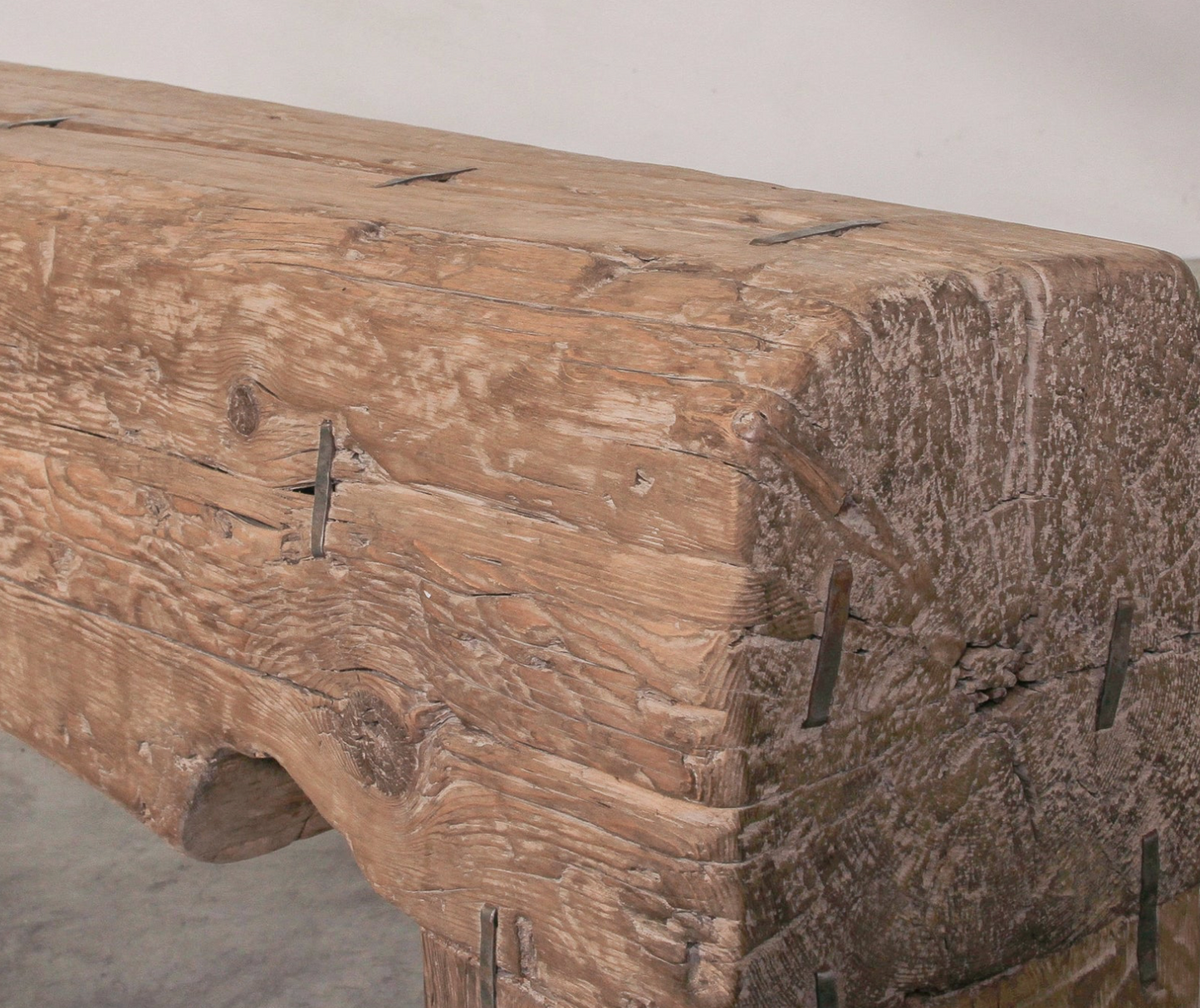 Wooden bench with rustic finish and metal brackets on a plain background