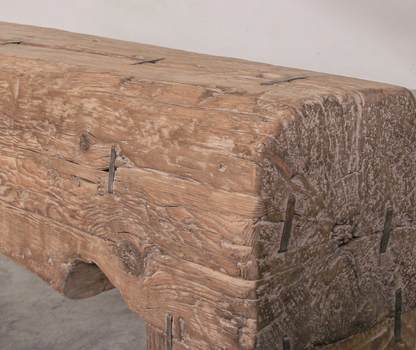 Wooden bench with rustic finish and metal brackets on a plain background