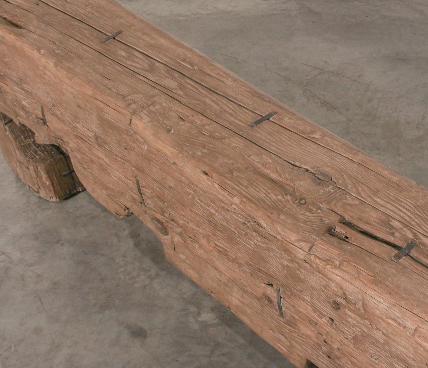 Wooden bench with metal brackets on a concrete floor