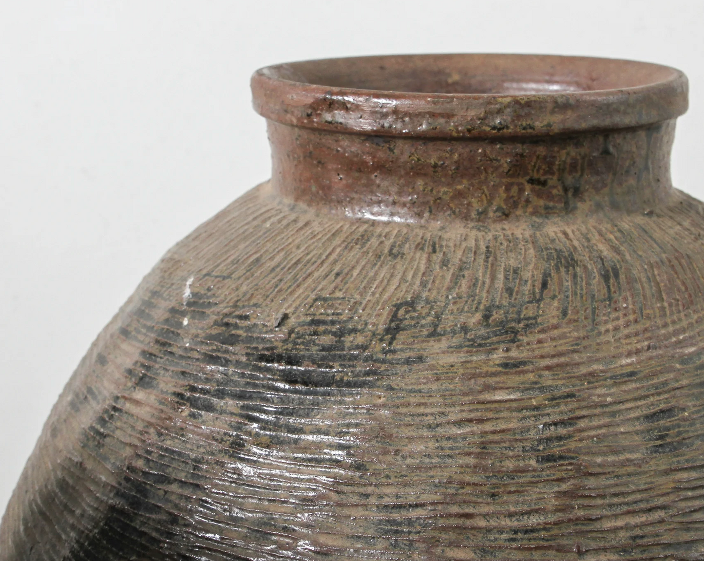 Close-up of a textured ceramic jar on a white background