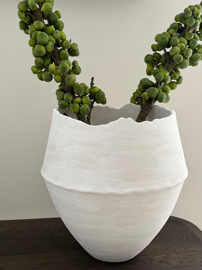 White textured planter with green plants on a wooden surface